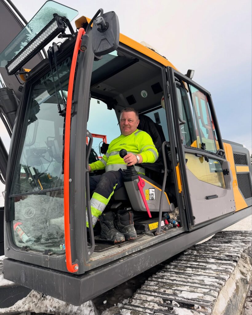 Foto av ansatt i gravemaskin