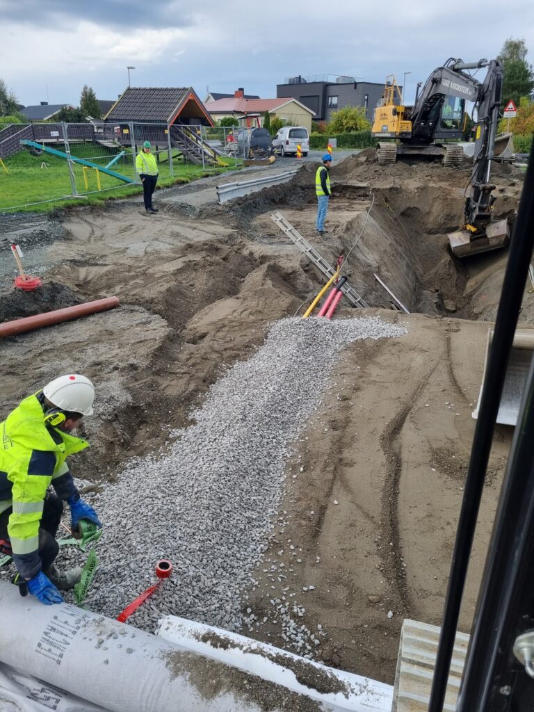 Mennesker som bedriver anleggs- og gravearbeid på vei i boligfelt